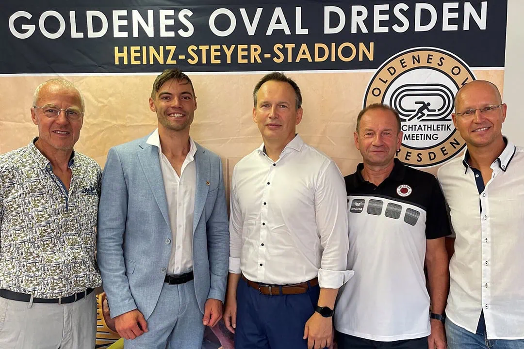 Das Bild zeigt eine Gruppe von Personen, die zusammen in einem goldenen Oval posieren, das ihre Gemeinschaft und Zusammenarbeit symbolisiert.
