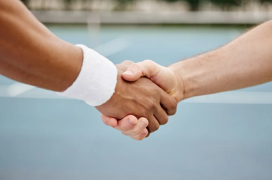 Das Bild zeigt die Hände eines Sportlers und eines Sponsors, die sich im Handschlag zur Bestätigung ihrer Zusammenarbeit vereinigen.